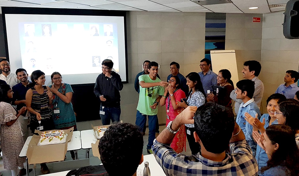 Employees enjoying a birthday celebration with two cakes at our office in India