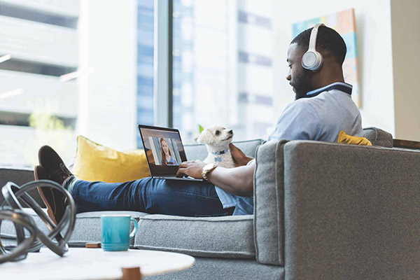 Man wearing Cisco Headset working on laptop