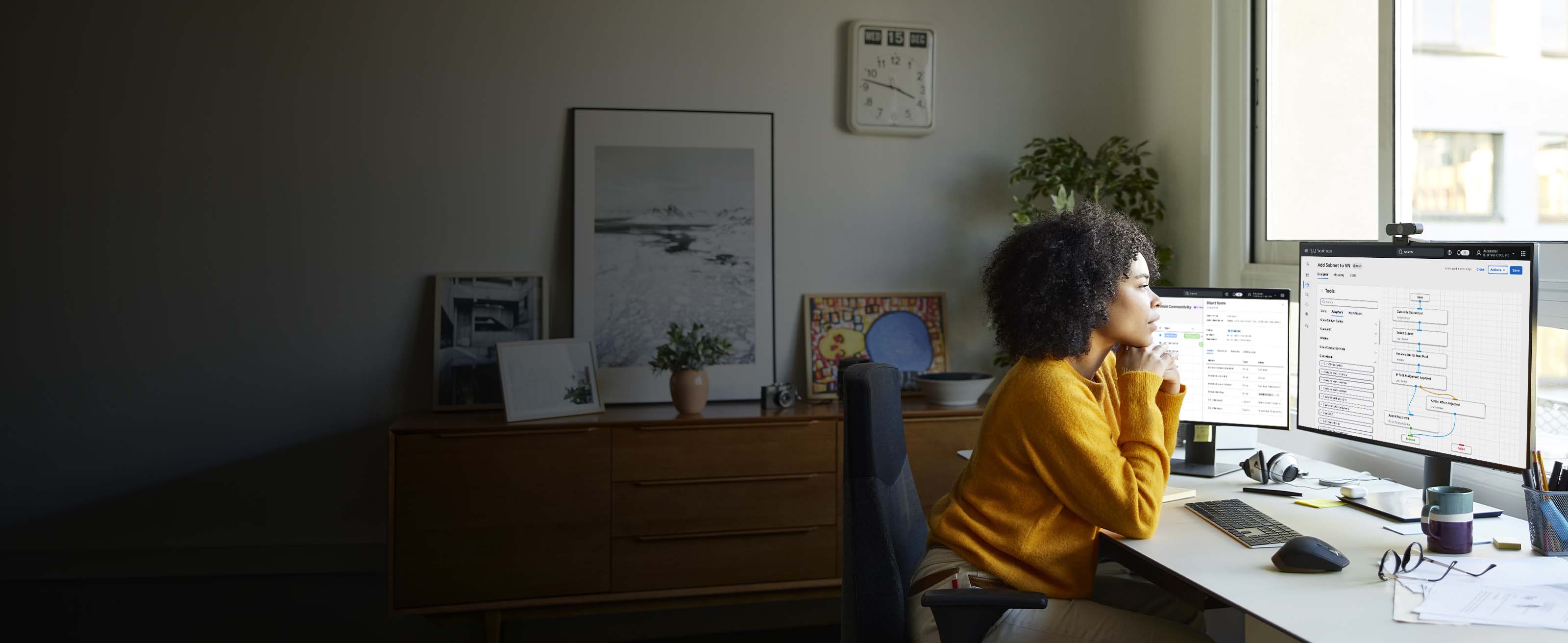 Tech worker at a desk looking at a monitor displaying a network architecture in the Cisco Networking Cloud